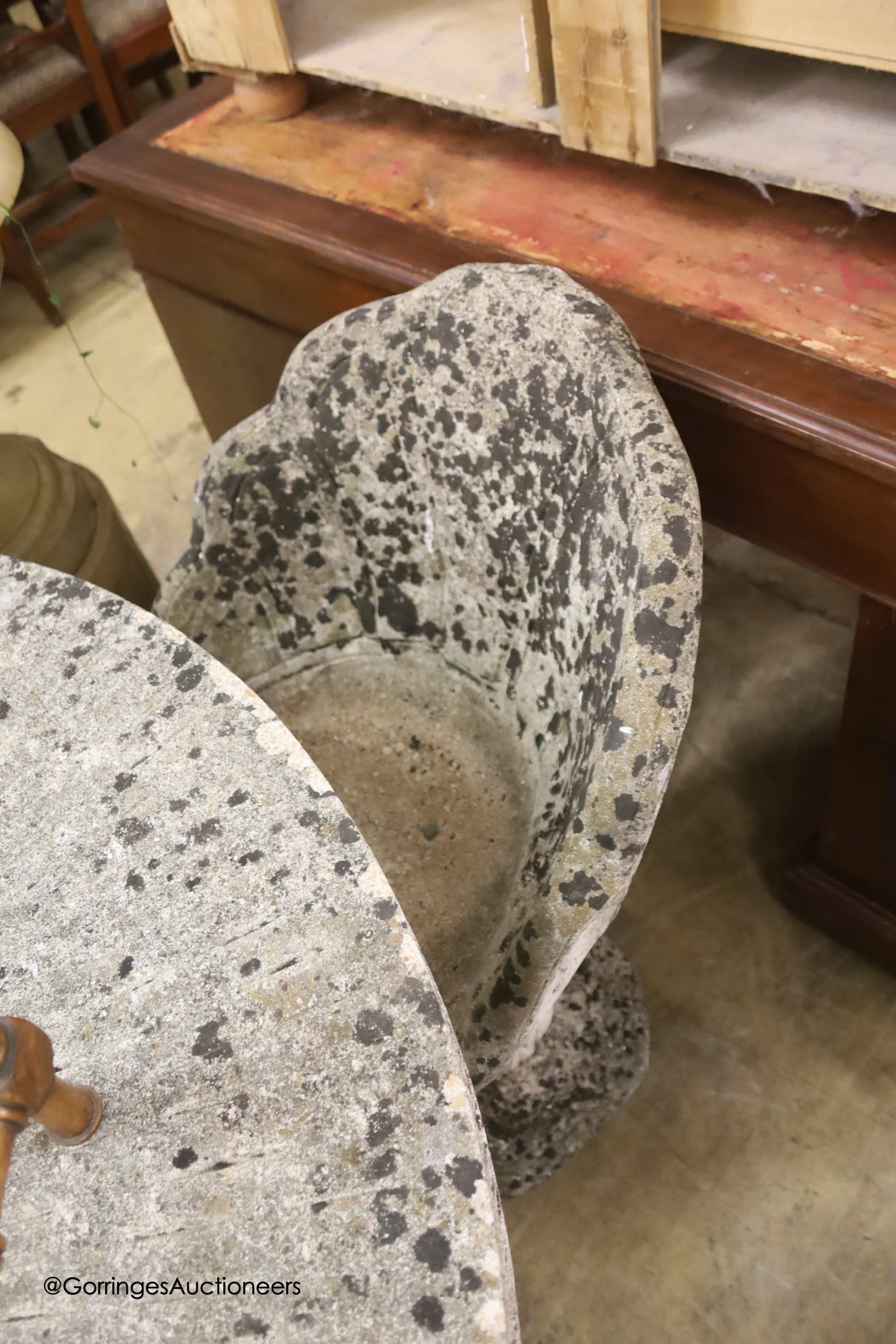 A circular reconstituted stone circular garden table, diameter 114cm, height 79cm and four matching chairs